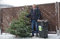 Mann hält Biotonne und Weihnachtsbaum