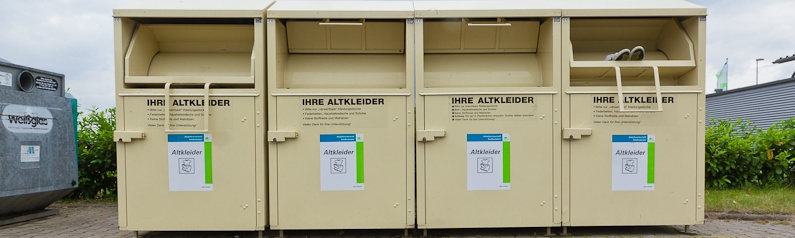 Vier Altkleidercontainer nebeneinander